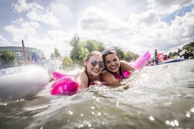 Zwei junge Frauen mit Schwimmfllügeln im Wasser