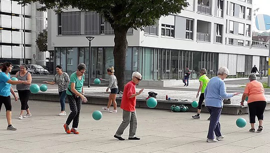 Seniorinnen trainieren im Freien mit Gymnastikbällen