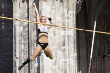 Stefanie Dauber beim Sprung, im Hintergrund das Portal des Münsters
